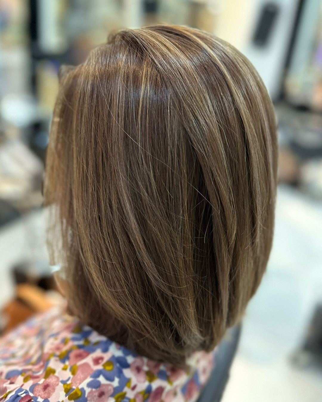 The back profile of a person's hair, showcasing short brown hair with light brown highlights