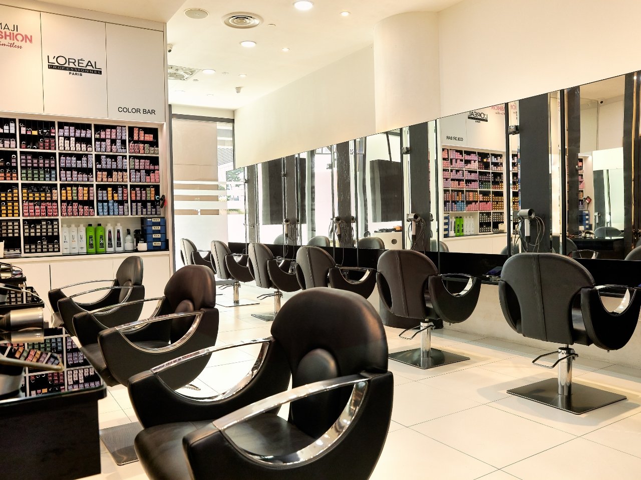 The interior of a salon with black salon chairs facing mirrors.