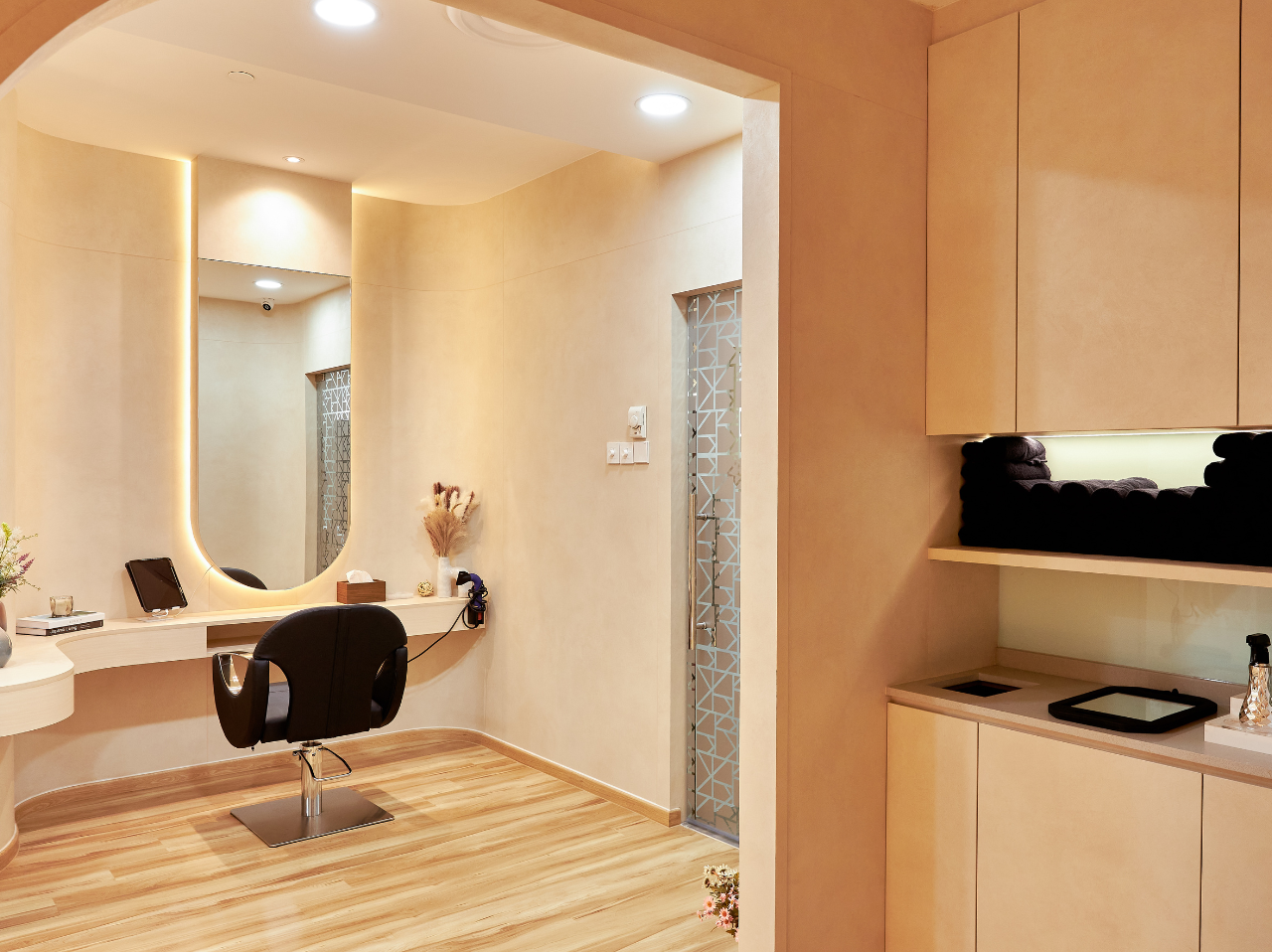 The interior of a hair salon showcasing a black chair facing a mirror